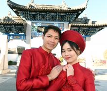 Arthur Lee and Grace Nguyen, of Auckland, dressed in traditional ao dai Vietnamese clothing,...