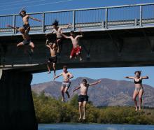A group of Mount Aspiring College students jump off the Albert Town Bridge in defiance of the...