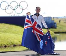 Lydia Ko poses with her gold medal and the New Zealand flag as she celebrates her Olympic victory...