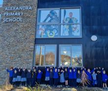 Alexandra Primary School pupils celebrate Finn Butcher's win in front of a window display of him...