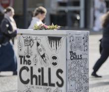 A floral posy placed on a traffic-control box featuring a tribute to Dunedin band The Chills in...