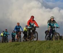 Colin Brown leads a group of cyclists along the Silver Stream floodbank near Mosgiel yesterday....