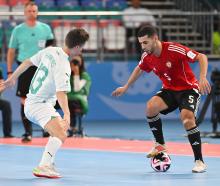 Futsal Whites player Oban Hawkins, of Dunedin, tries to shut down Libyan attacker Siliman...