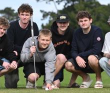 University of Otago commerce student Tommy Cummins, 19, lines up a shot under the eagle eye of...