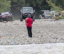 A protester stands in front of a row of 4WD vehicles to try and protect the endangered nesting...