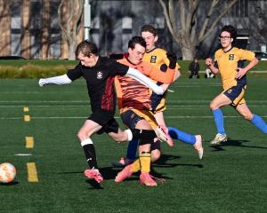 Logan Park footballer Sam Heron gets past Taieri goalkeeper Murray Boyne and defenders Jack...