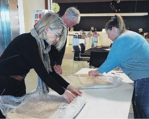 Committee member Lynda Scott (right) checks in some of the new work. PHOTO: SUPPLIED
