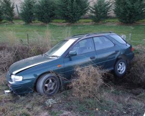 A car in a ditch off Malaghans Rd. Photo by Christina McDonald.