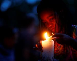 A girl lights candles outside the house where Nelson Mandela died in Johannesburg as South...
