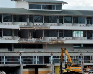 A mechanical excavator stands beneath  Carisbrook's terrace hospitality complex as demolition of...