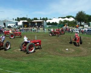 Four pairs of vintage Farmall H tractors perform a "tractor dance" at the 98th West Otago A and P...