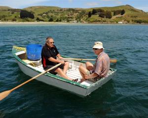 Bob Mitchell (left) and Des Gray, both of Otakou, paddle on after setting a net for moki off...