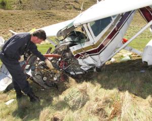 Civil Aviation Authority safety investigator Colin Grounsell  examines  the wreckage of the...