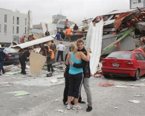 CTV staff comfort each other as rescue personnel work to rescue people trapped in the collapsed...