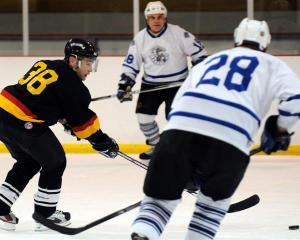 In action at the Dunedin Ice Stadium are (from left) Queenstown Jurassics player Chris Hansen and...