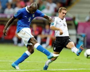 Italy's Mario Balotelli scores his second goal despite the attentions of Germany's Philipp Lahm....