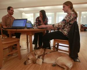 Jessie Lorenz (right) who is blind, sits with her dog Nacho as she works with engineer Mike...