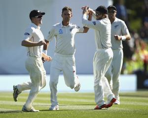 New Zealand's Trent Boult (2nd L) celebrates with teammates after taking the wicket of Australia...