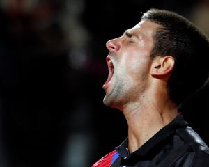 Novak Djokovic of Serbia celebrates after winning his semifinal match against Roger Federer of...