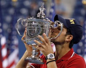 Novak Djokovic of Serbia kisses his trophy after defeating Rafael Nadal of Spain in the men's...