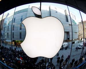 People wait on a street in front of an Apple store in Munich as they await sales of the new iPad...
