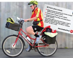 Postie Jane Gibbs heads down Ascot St in Dunedin yesterday. Photo by Peter McIntosh.