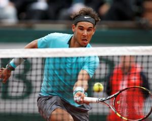 Rafael Nadal reaches out to return a forehand to Dominic Thiem. REUTERS/Jean-Paul Pelissier