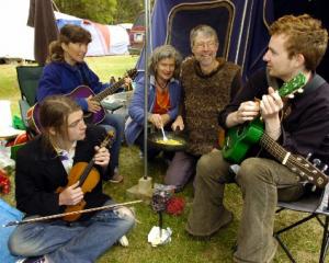 Relaxing outside their tent at last year's Whare Flat Folk Festival are (front, from right) Khris...