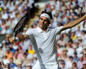 Roger Federer hits a return against Milos Raonic.  REUTERS/Facundo Arrizabalaga/Pool