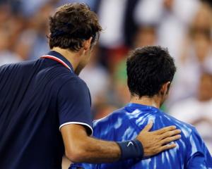 Roger Federer of Switzerland (L) pats Bjorn Phau of Germany on the back after defeating him at...