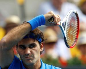 Roger Federer of Switzerland returns the ball to Tomas Berdych of the Czech Republic during their...