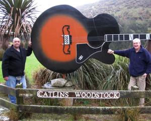 Russell Kirk (right) hands over the Catlins Woodstock Festival to Kev Thompson. Photo supplied.