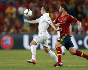 Spain's Xabi Alonso challenges France's Franck Ribery (L) during their Euro 2012 quarterfinal at...