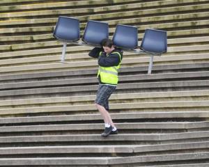 Thomas Smith (18), of Mosgiel, carries seats at the Carisbrook garage sale in Dunedin on Saturday.