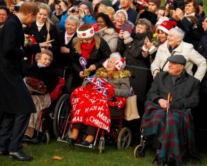 Prince Harry greets well wishers as he leaves the Christmas Day church service in Sandringham....