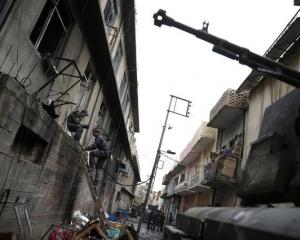 A member of the Iraqi Federal Police climbs up a ladder in a street next to the frontline during combat with Islamic State in western Mosul. Photo: Reuters