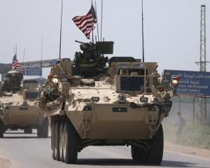 US military vehicles travel in the northeastern city of Qamishli, Syria. Photo: Reuters