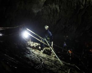 Divers walk inside Tham Luang cave complex in the northern province of Chiang Rai. Photo: Reuters