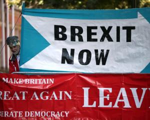 A crown-wearing pro-Brexit demonstrator stands next to banners in London last week. Photo: Reuters