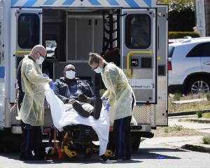 Ambulance staff lift a patient that was identified to have coronavirus disease (COVID-19) into an...