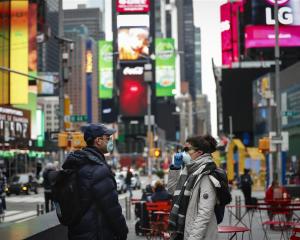 People walk through a nearly empty Times Square in New York City. Photo: Reuters