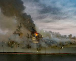 Boats combat a fire on board the US Navy amphibious assault ship USS Bonhomme Richard. Photo: U.S...