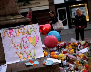 People look at flowers for the victims of the Manchester Arena attack. Photo: Reuters