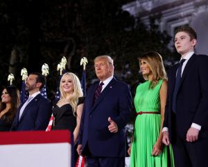 President Donald Trump gives a thumbs-ups next to first lady Melania Trump and their extended...