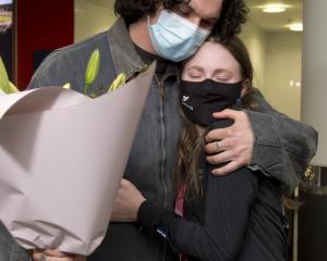 Long jump gold medallist Anna Grimaldi is greeted home by partner Felix McDonald at the airport...