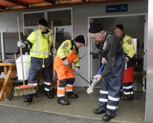 Omarama Volunteer Fire Brigade station officer Maurice Cowie wrings out his mop while (from left)...