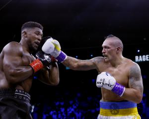 Oleksandr Usyk hits Anthony Joshua with a punch during his defence of the WBA, WBO and IBF...
