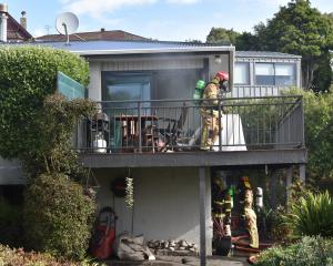 Personnel from Fire and Emergency New Zealand and police work at a house fire in Vauxhall...