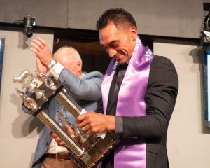 Southern shearer Leon Samuels collects the trophy after winning the recent Golden Shears open...