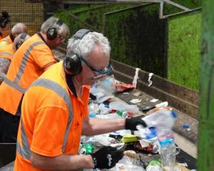 Workers manually separate the recycled items coming in on a conveyer belt. Photos: RNZ/Jimmy...